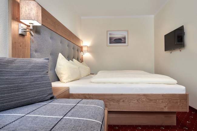 Schlafzimmer mit Doppelbett & Couch im Appartement D - Villa Sunshine Flachau