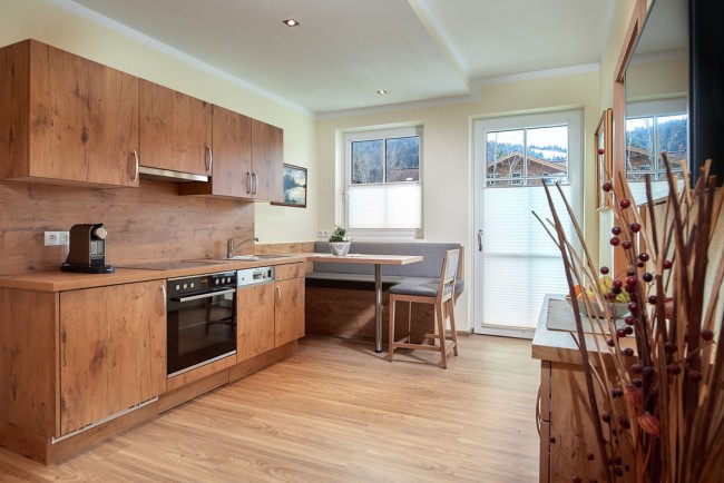 Küche mit Esstisch, Flat-TV und Balkon im Appartement D - Villa Sunshine Flachau