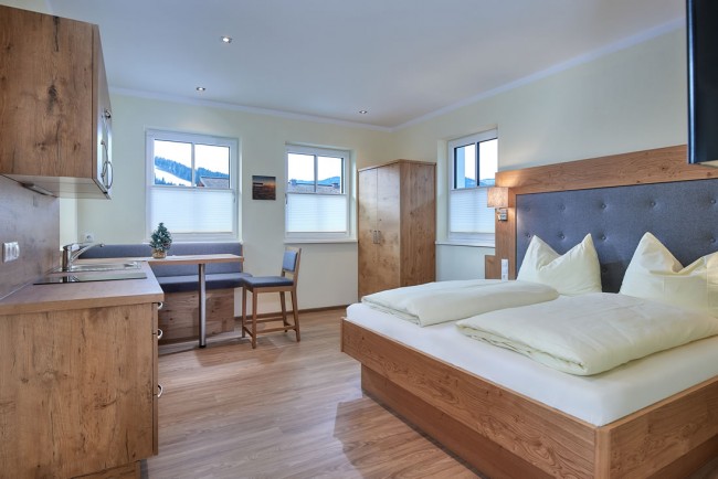 Wohnschlafraum mit Doppelbett und Esstisch im Appartement E - Villa Sunshine in Flachau