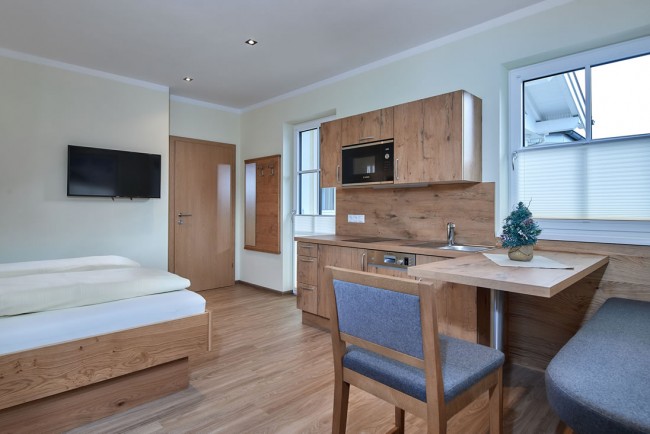 Wohnschlafraum mit Küchenzeile, Essecke und Doppelbett im Appartement E - Villa Sunshine in Flachau